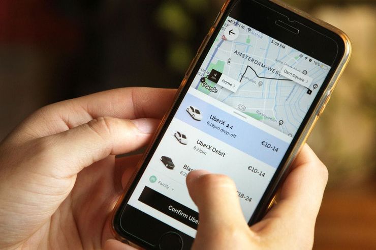 Smartphone with opened Uber on it in human hands