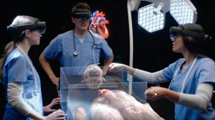 Three doctors wearing VR glasses observe a human heart